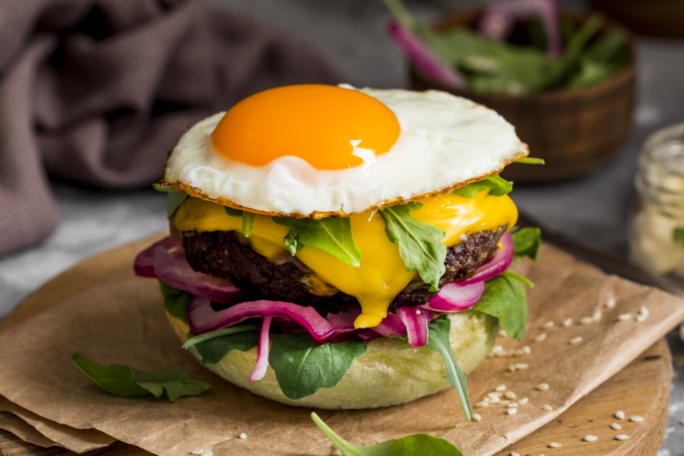burger-a-angle-eleve-avec-oeuf-frit-sur-une-planche-a-decouper