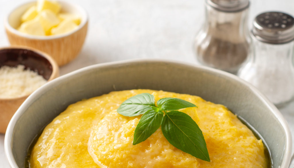 Polenta,With,Butter,And,Parmesan,Cheese,In,Bowl,On,Concrete