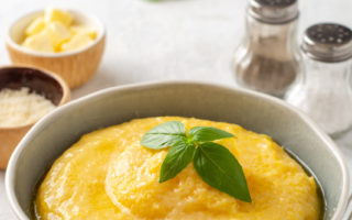 Polenta,With,Butter,And,Parmesan,Cheese,In,Bowl,On,Concrete