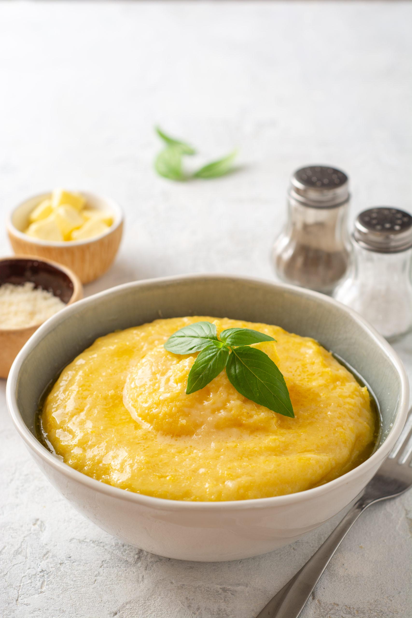 Polenta,With,Butter,And,Parmesan,Cheese,In,Bowl,On,Concrete