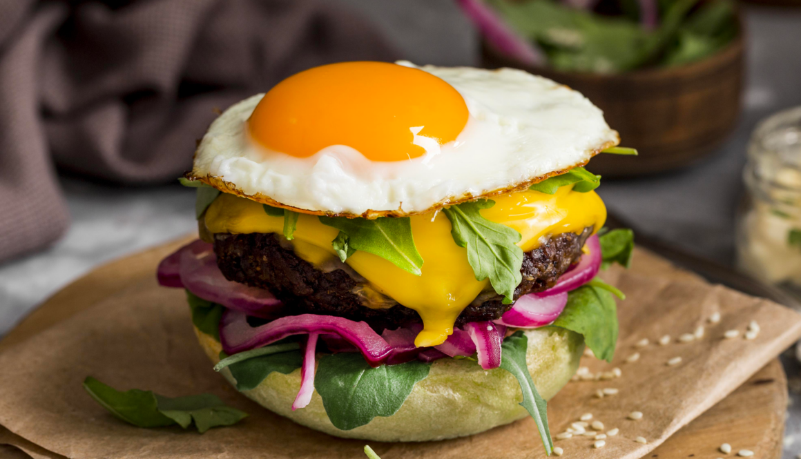 burger-a-angle-eleve-avec-oeuf-frit-sur-une-planche-a-decouper